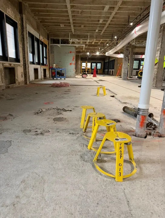 Row of HoleMole Stands over core holes on a Troop Contracting jobsite floor